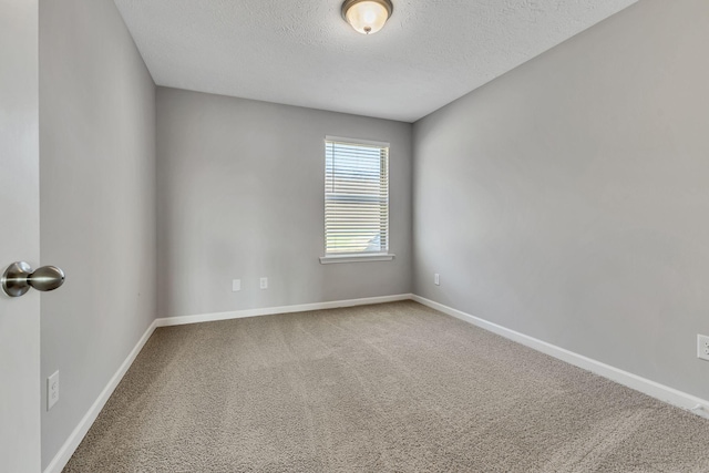 unfurnished room featuring carpet and a textured ceiling