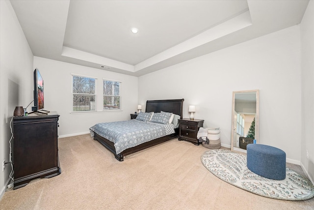 carpeted bedroom featuring a tray ceiling