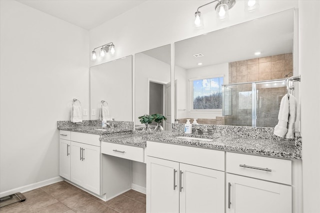 bathroom featuring a shower with shower door, vanity, and tile patterned flooring