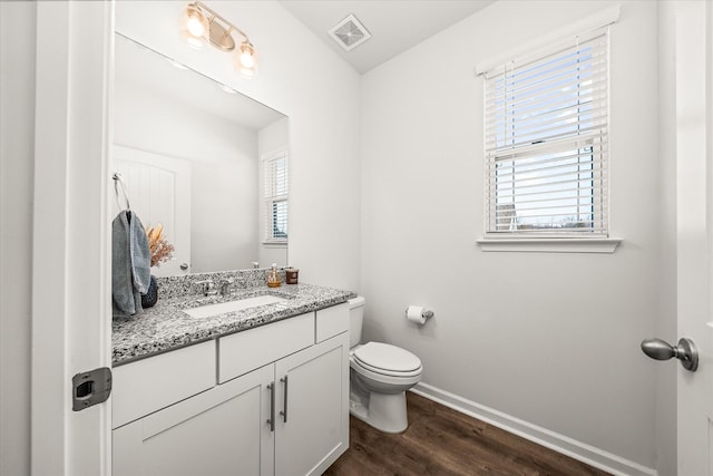 bathroom featuring toilet, hardwood / wood-style flooring, and vanity