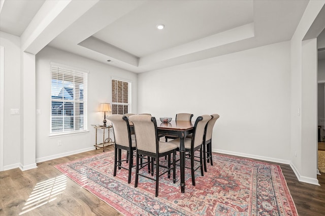 dining space featuring dark hardwood / wood-style flooring and a raised ceiling