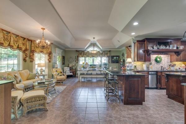 kitchen featuring lofted ceiling, backsplash, a notable chandelier, a breakfast bar, and crown molding