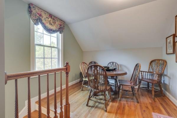 dining space with lofted ceiling and hardwood / wood-style floors