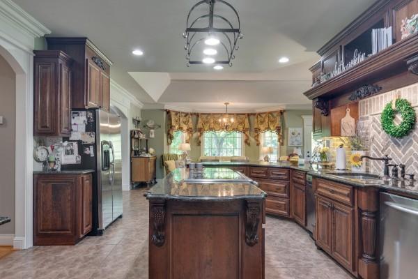 kitchen featuring kitchen peninsula, sink, crown molding, hanging light fixtures, and stainless steel appliances