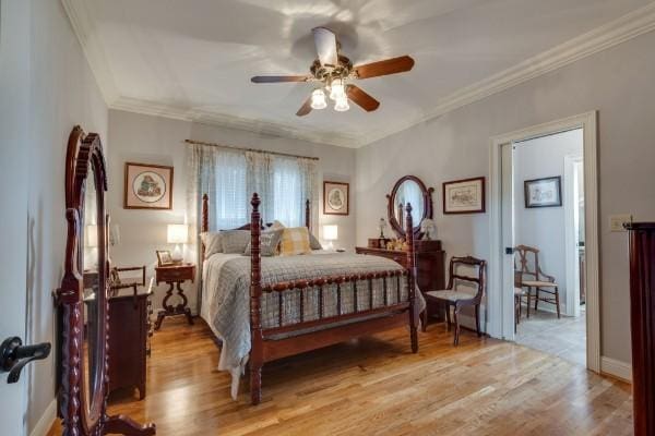 bedroom featuring ceiling fan, ornamental molding, and light hardwood / wood-style flooring