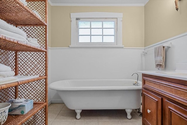 bathroom with tile patterned floors, a bath, ornamental molding, and vanity