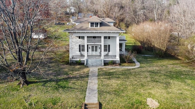 view of outdoor structure featuring covered porch and a yard