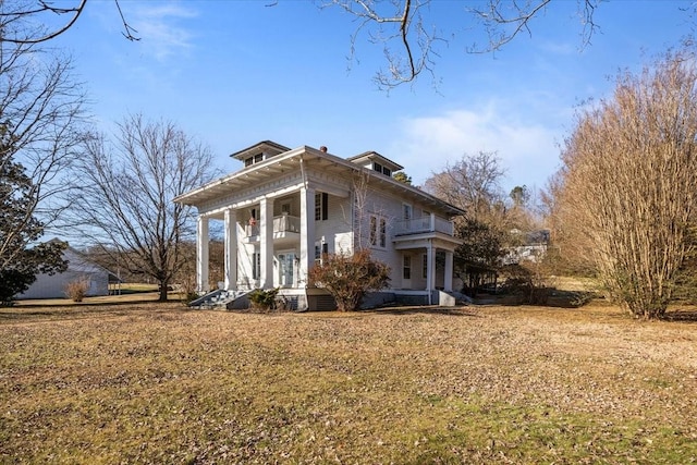 exterior space featuring a front lawn, a porch, and a balcony