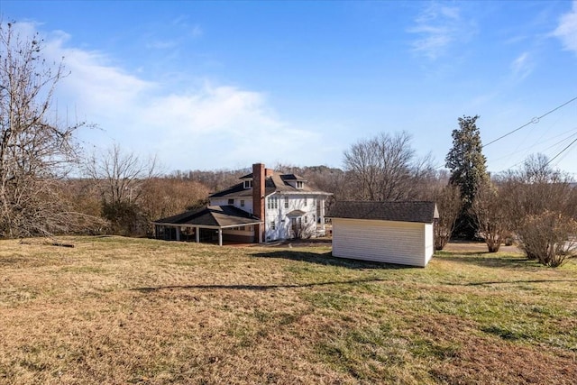 back of house with a yard and a shed