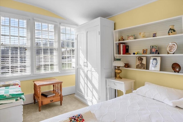 bedroom featuring multiple windows, light carpet, and vaulted ceiling