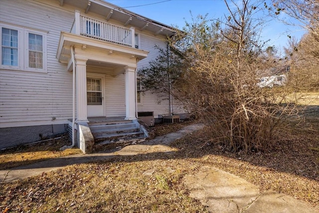 entrance to property with central AC unit and a balcony