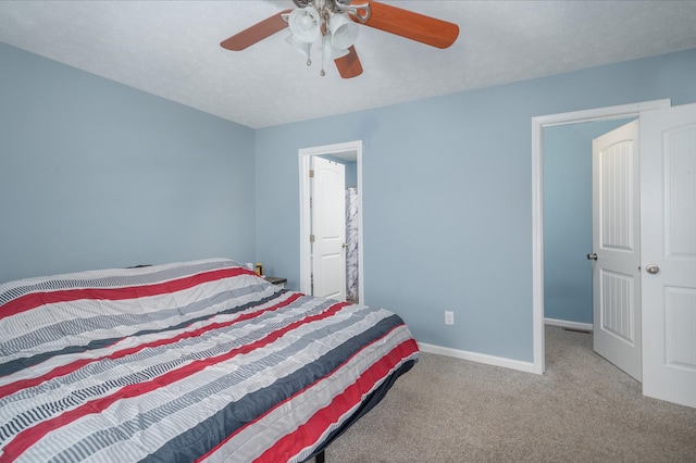 bedroom featuring ceiling fan, light carpet, and a textured ceiling