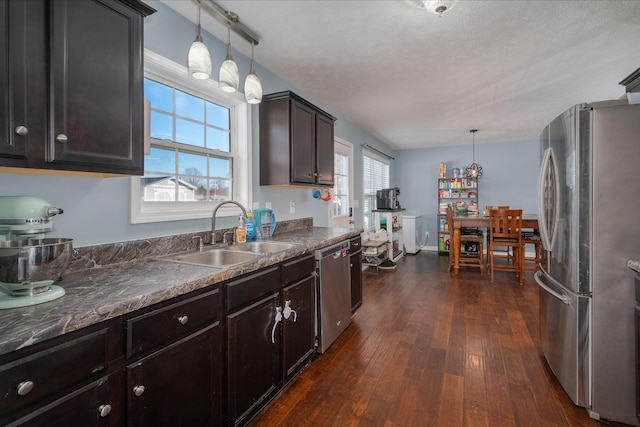 kitchen with sink, decorative light fixtures, dark hardwood / wood-style floors, and appliances with stainless steel finishes