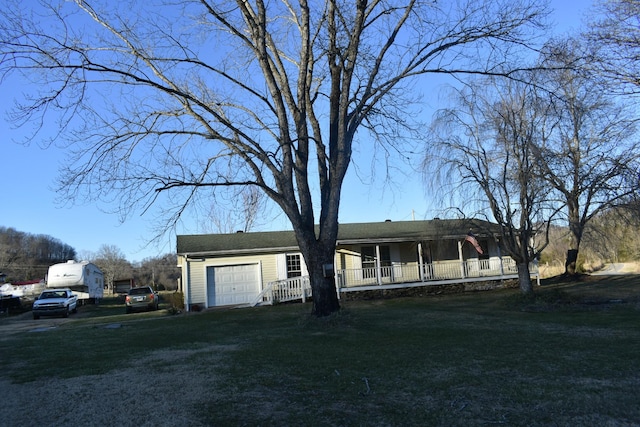 view of front facade with a front yard, a porch, and a garage