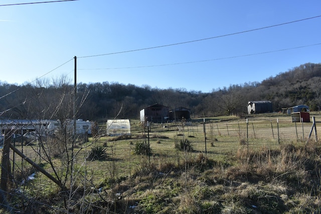 view of yard featuring a rural view and an outdoor structure