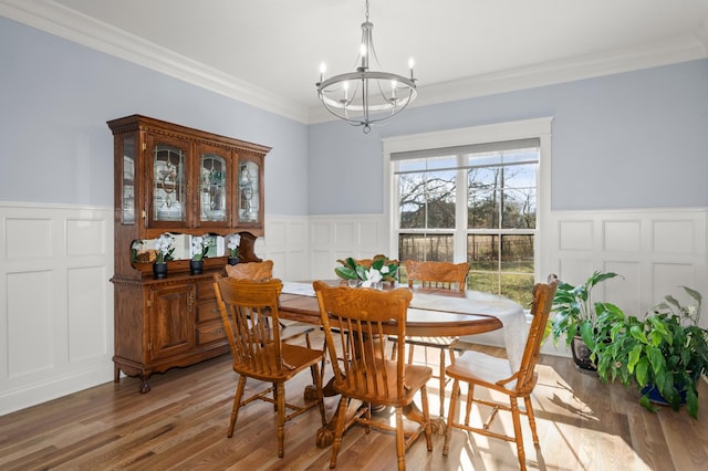 dining room with an inviting chandelier, hardwood / wood-style flooring, and ornamental molding