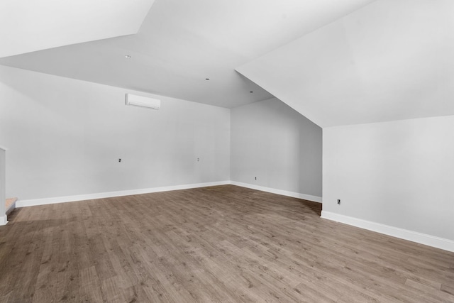 bonus room with light hardwood / wood-style floors and vaulted ceiling