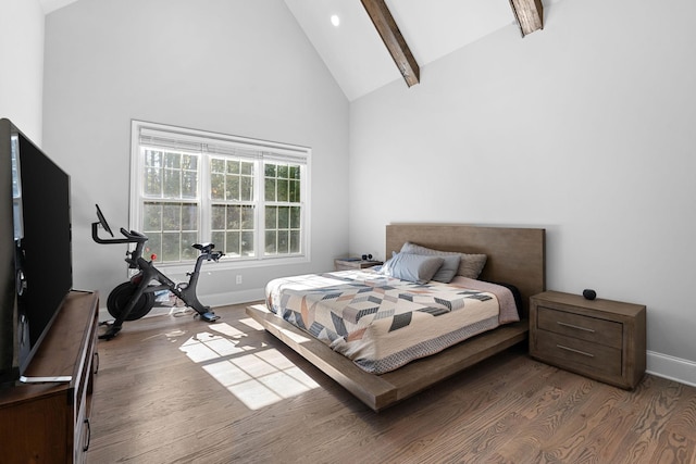 bedroom with high vaulted ceiling, hardwood / wood-style floors, and beam ceiling