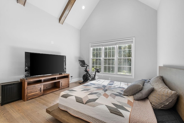 bedroom featuring light hardwood / wood-style floors, beamed ceiling, high vaulted ceiling, and radiator