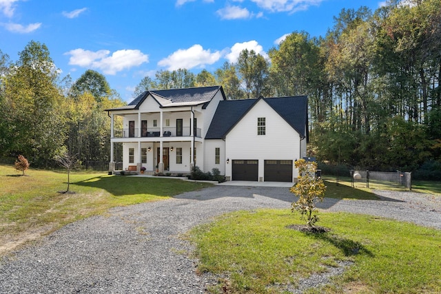 view of front facade featuring a balcony, a garage, covered porch, and a front lawn