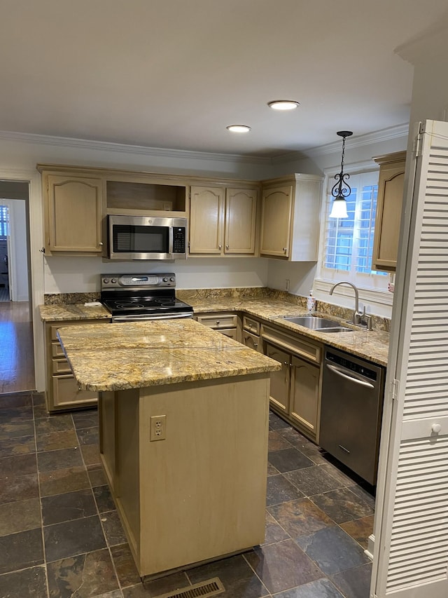 kitchen with sink, stainless steel appliances, a center island, ornamental molding, and decorative light fixtures