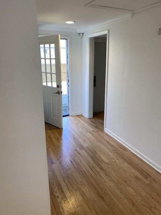 unfurnished room featuring crown molding and light wood-type flooring