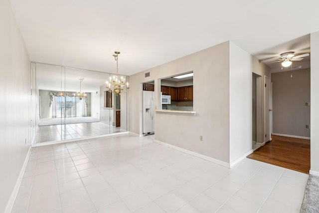 interior space featuring ceiling fan with notable chandelier and light tile patterned floors