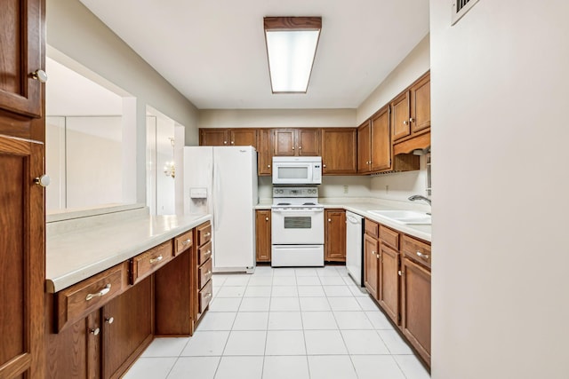 kitchen featuring sink, white appliances, and light tile patterned floors