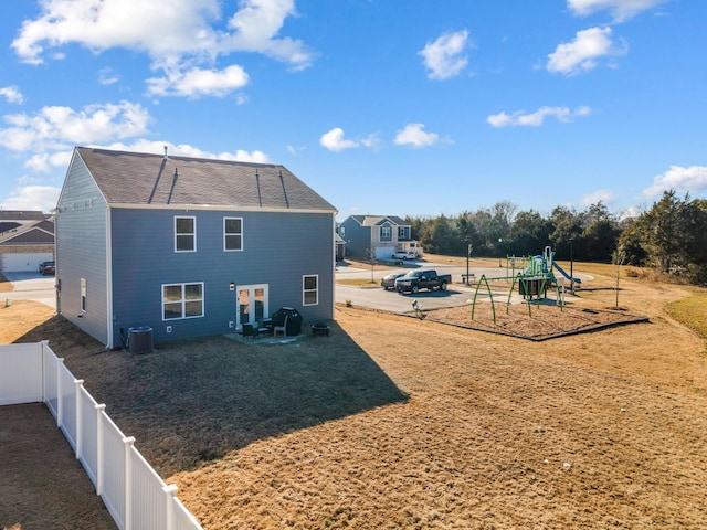 back of property featuring a playground and central AC unit