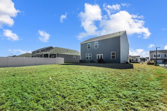 rear view of house with cooling unit and a yard