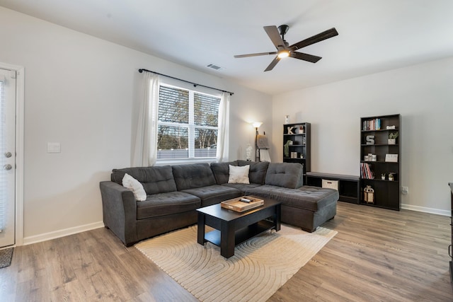 living room featuring wood-type flooring and ceiling fan