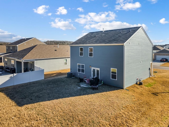 rear view of property featuring a yard and central AC