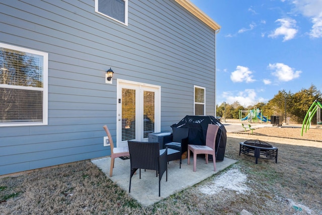 view of patio featuring an outdoor fire pit, grilling area, and a playground