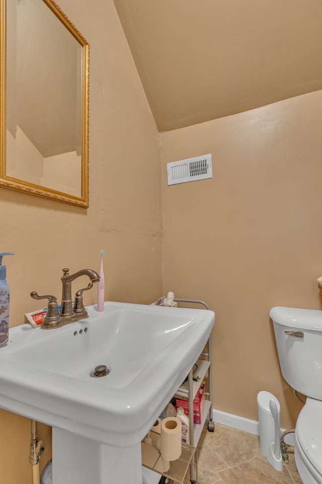 bathroom featuring sink, tile patterned floors, toilet, and vaulted ceiling