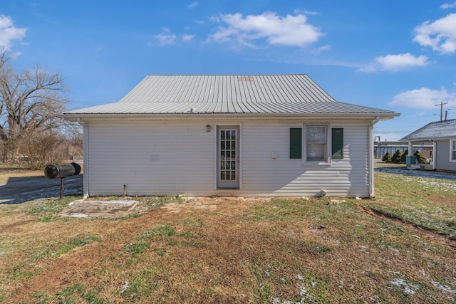 rear view of property featuring a lawn