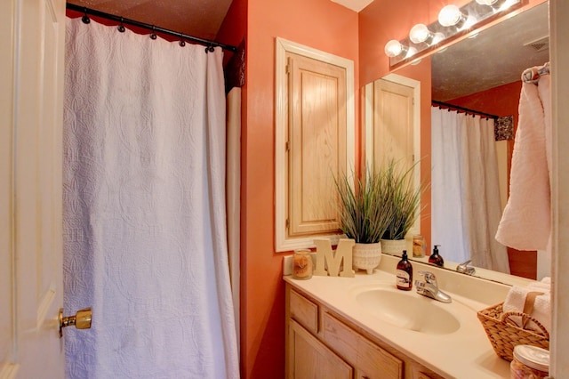 bathroom featuring walk in shower and vanity