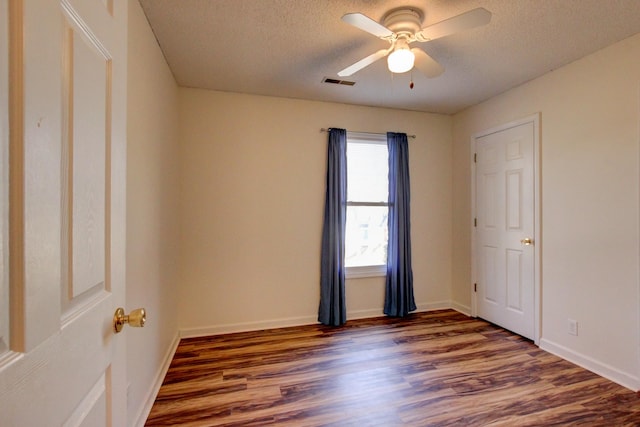 spare room featuring a textured ceiling, dark hardwood / wood-style floors, and ceiling fan