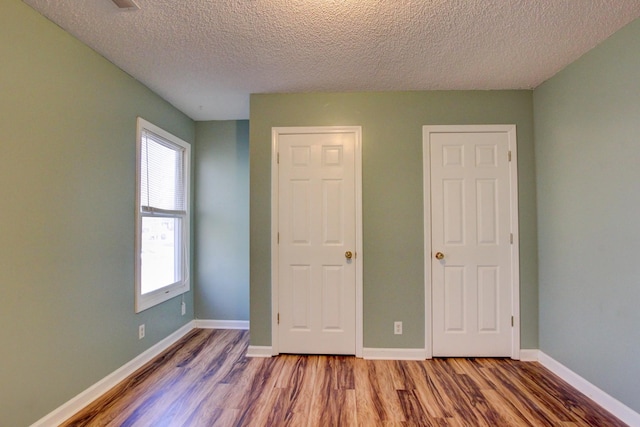 unfurnished bedroom featuring hardwood / wood-style flooring and a textured ceiling