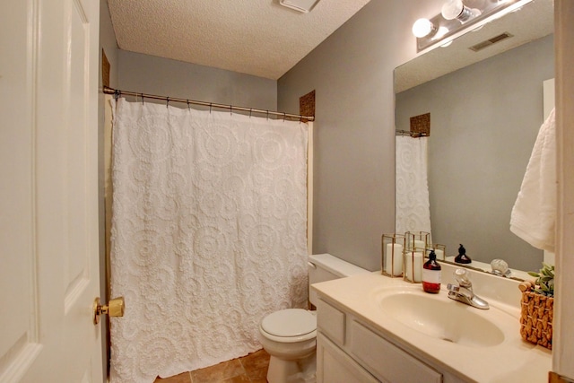 bathroom with vanity, toilet, tile patterned flooring, and a textured ceiling