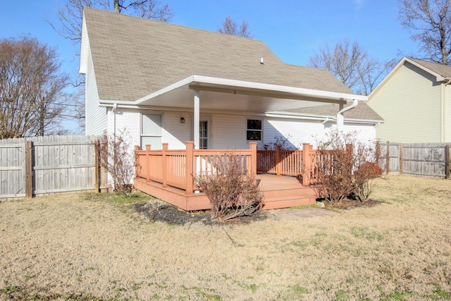 rear view of house with a wooden deck and a yard