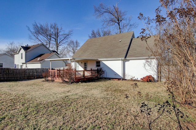 rear view of house featuring a deck and a lawn