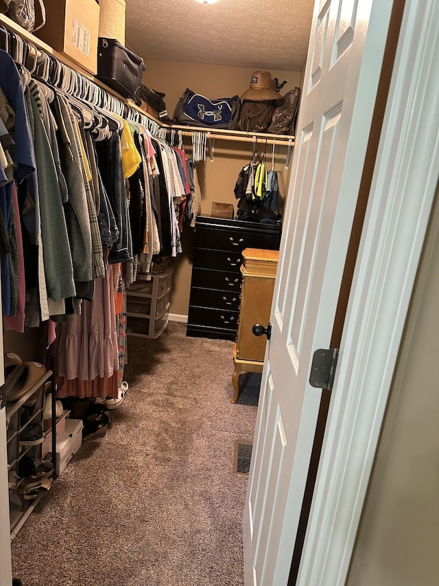 spacious closet featuring dark colored carpet