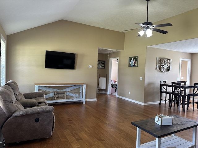 living room featuring ceiling fan, dark hardwood / wood-style floors, and vaulted ceiling