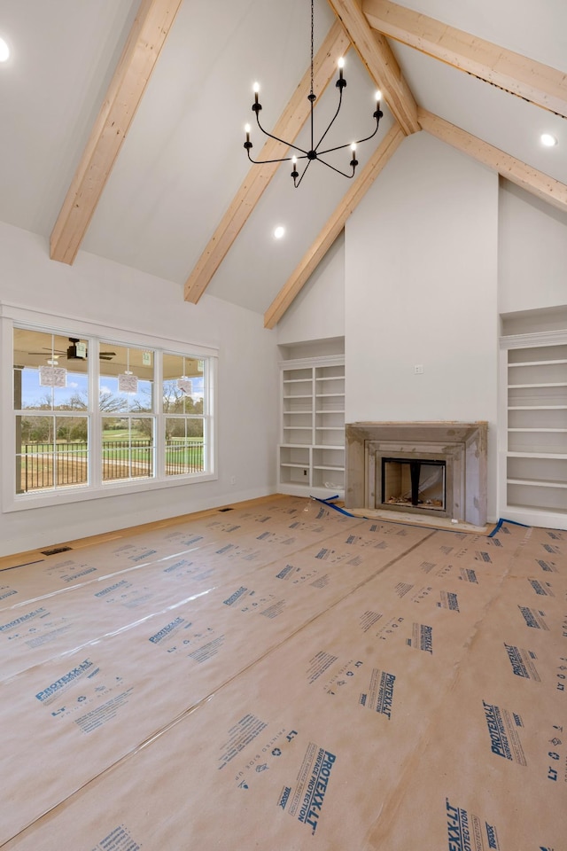 unfurnished living room featuring a notable chandelier, high vaulted ceiling, beam ceiling, and a fireplace