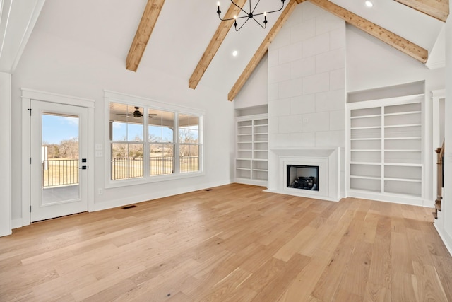 unfurnished living room featuring a fireplace, light wood finished floors, a chandelier, high vaulted ceiling, and beamed ceiling