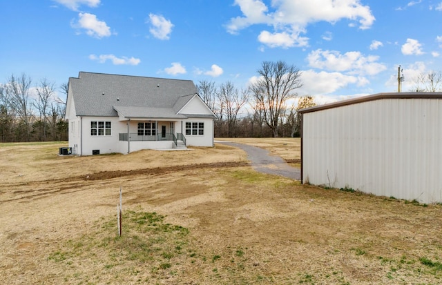 back of house with a porch and a yard