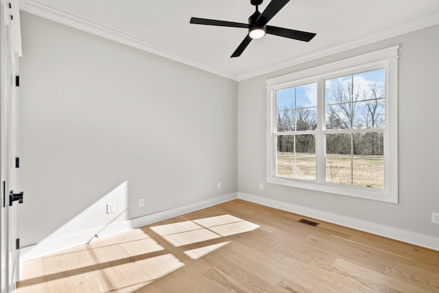 unfurnished room with baseboards, visible vents, a ceiling fan, light wood-style flooring, and crown molding