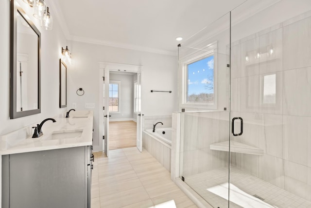 bathroom featuring a garden tub, a shower stall, a sink, and crown molding