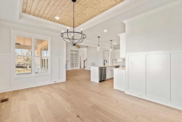 unfurnished dining area featuring wooden ceiling, a tray ceiling, a decorative wall, and a sink