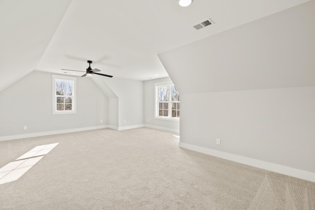 additional living space featuring vaulted ceiling, a healthy amount of sunlight, visible vents, and baseboards